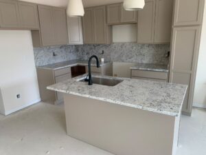 Full kitchen view with speckled granite countertops and a matching full-height backsplash