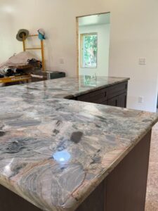 Kitchen island countertop with dramatic warm-toned granite in rust, grey, and beige tones