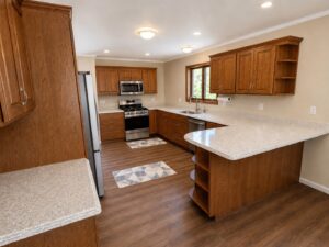 U-shaped kitchen with light speckled quartz countertops and warm oak cabinetry